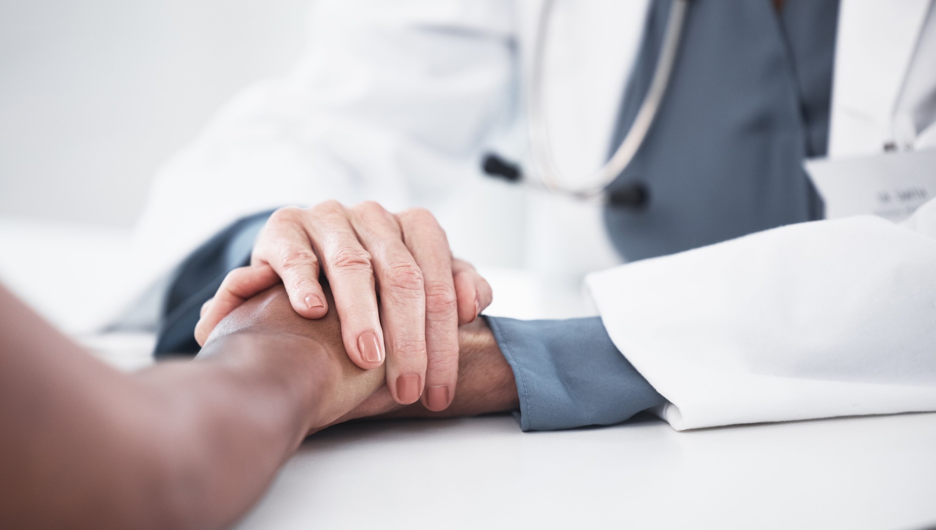 Shot of a doctor holding hands with her patient during a consultation