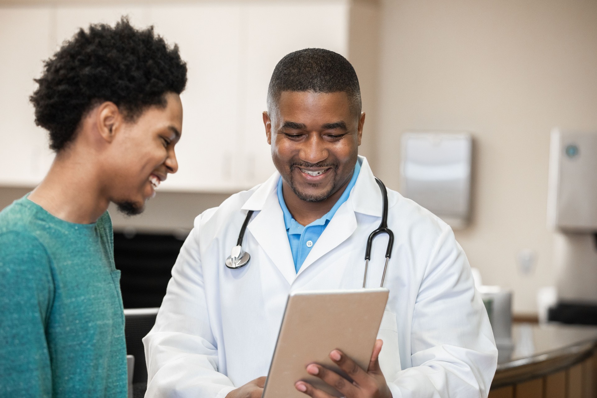 Doctor and patient looking at digital tablet in exam room