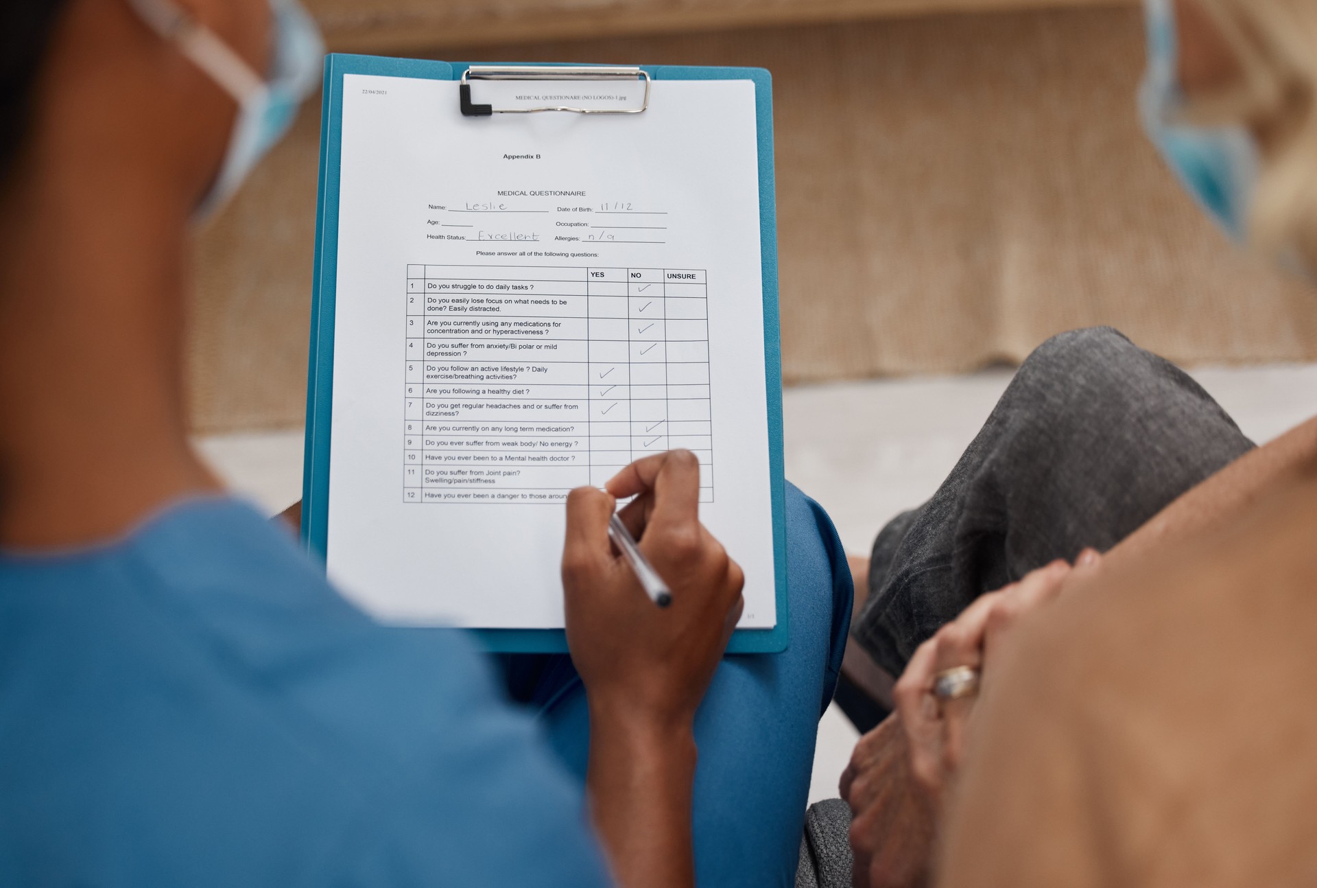 Shot of a doctor filling out a questionnaire during a consultation with a senior woman at home