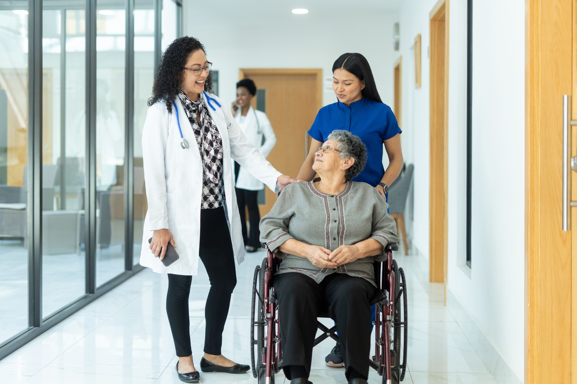 Female doctor and her patient connect while they stroll down the hallway